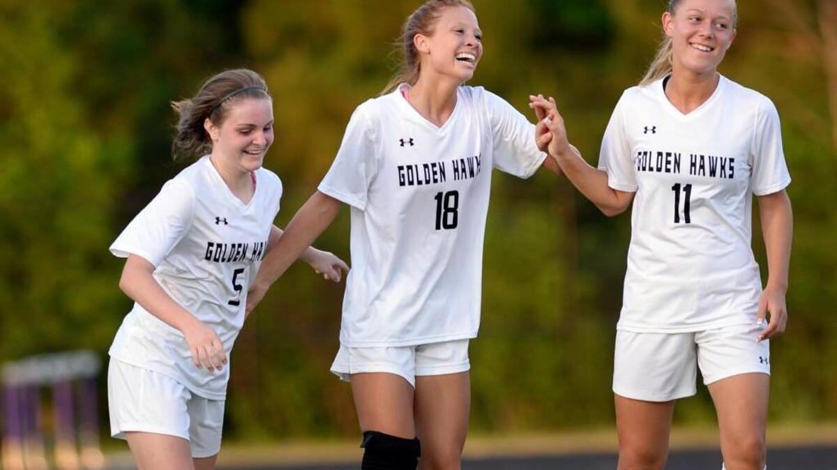 Holly Springs teammates Andie O'Connell (5) and Jackie Blendermann (11) help Sierra Raynor (18), celebrate after Raynor scores the her team's first goal of the evening. Holly Springs hosted Panther Creek for a women's soccer game, which was played on Monday, April 25, 2016. Holly Springs won 2-1.