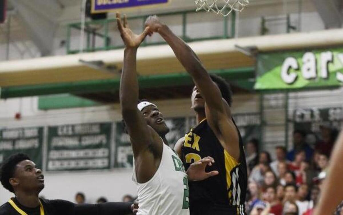 Cary's Donte Tatum (23) shoots over Apex's Chavis Coachman (33) in Cary, N.C. on Friday, December 2, 2016. Apex won 63-58.