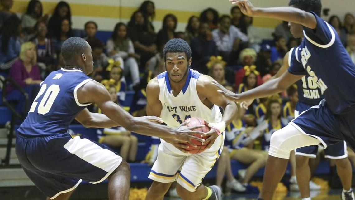 East Wake's Brandon Mitchell (34) runs the gauntlet between Smithfield-Selma's Rashad Potts (20) and Isaiah Watson (5) as he goes to the basket for a shot. Coverage from prep basketball between the East Wake Warriors and the Smithfield-Selma Spartans played in Wendell, N.C. on Wednesday, November 16, 2016. The East Wake boys defeated Smithfield-Selma 78-59.