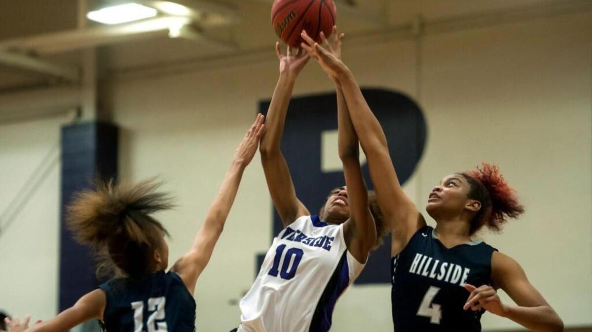 Riverside's Abira Reddish shoots between Hillside's Faith Blackstone and Elisia Grissett during the second half of Tuesday's game in Durham.