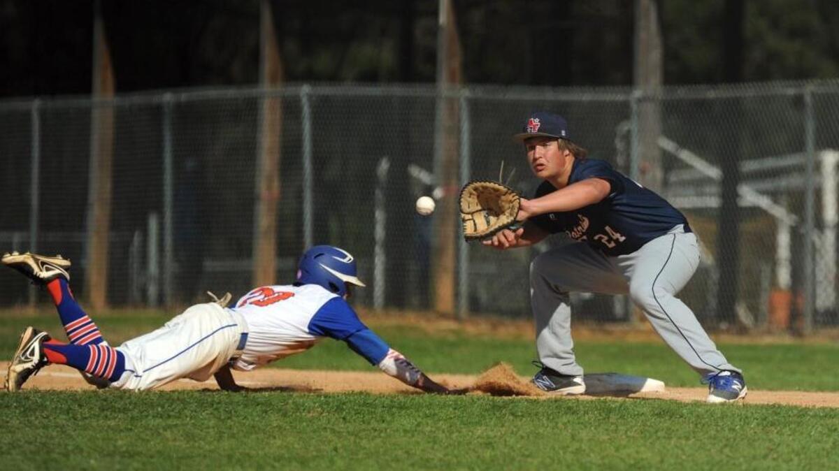 Athens Drive’s Keith Markovich (20) slides in under the tag by Apex Friendship's Luke Cerasi (24) during the baseball game, which was played in Raleigh on Thursday, March 24, 2016. Athens Drive won 10-0 in 5 innings.