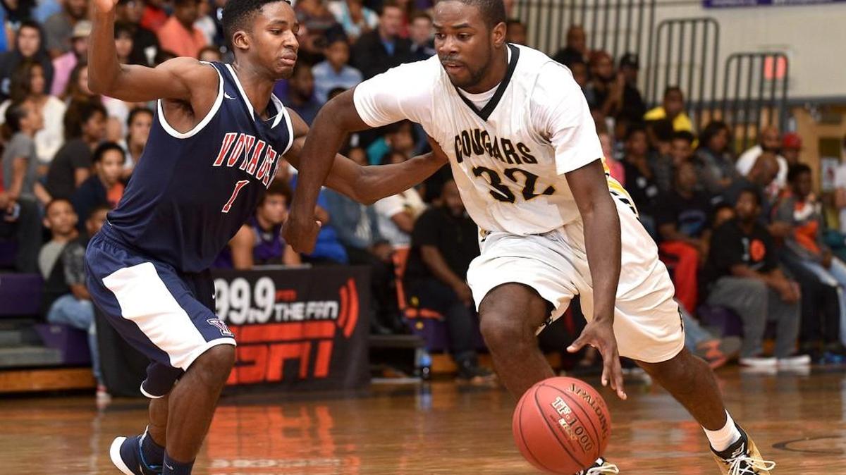 Apex's Ian Boyd (32) drives to the lane while guarded by Voyager's Nelson White (1) during the second half. The Apex Cougars took on the Voyager Academy Vikings in the first round of the HighschoolOT.com Holiday basketball tournament at Broughton High School in Raleigh, N.C. on Saturday December 26, 2015. Voyager Academy wins 81-65.