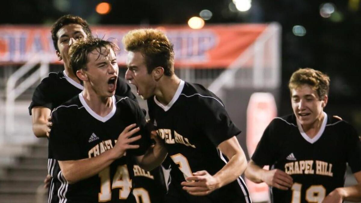 Chapel Hill's Ryan Smith (9) celebrates his late goal with teammates including Matt Arnold (14). The Chapel Hill Tigers played against the A. C. Reynolds Rockets in the 3A NCHSAA State Championship in Raleigh on Saturday, November 18, 2017. Chapel Hill won the game 2-0.