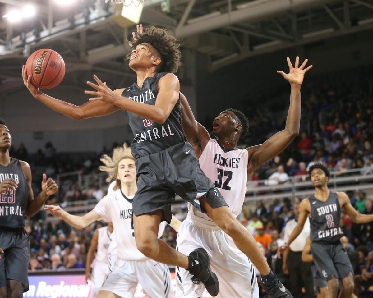 South Central's Shykeim Phillps (3) takes the ball by Heritage's Jarren McAllister (32) on a reverse layup. The South Central Falcons and the Heritage Huskies played in the boys 4A Eastern Regional basketball finals at East Carolina University on Saturday, March 3, 2018.
