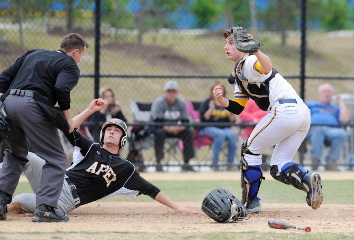 Apex's Tucker Jackson (23) is tagged out by Garner catcher Nolan McLean (11) in Garner, N.C. on Tuesday, May 9, 2017. Garner won 5-4.