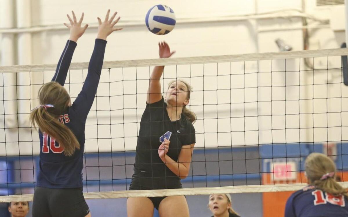 Louisburg's Whitney Bolton (4) sends a shot by Franklin Academy's Brittany Harris (10) for a Warrior point. Coverage from the 1A NCHSAA volleyball championship tournament game between the Louisburg Warriors and the Franklin Academy Patriots played in Louisburg, N.C. on Saturday, October 29, 2016. Louisburg defeated Franklin Academy 3-0 to advance to the 4th round of the tournament.