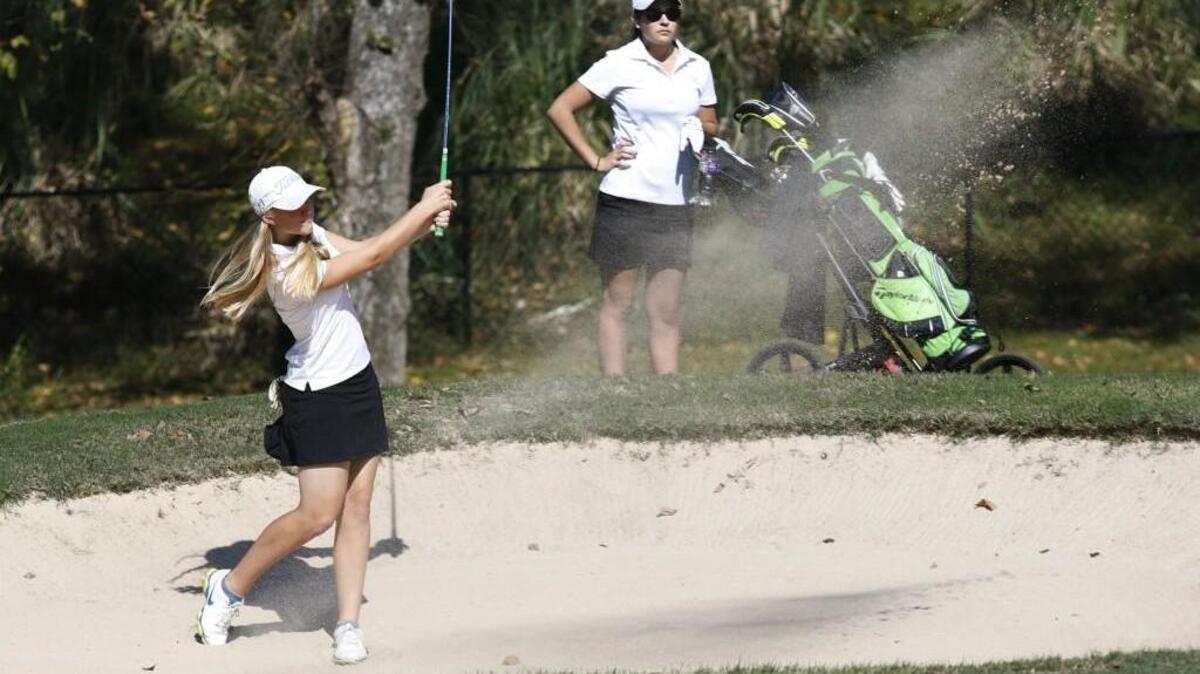 
From left, Cardinal Gibbons golfer Riley Smyth hits out of the sand trap toward the 5th hole while competitor Logan McClamroch of Northwood High school watches during play Tuesday afternoon, October 13, 2015 at the Chapel Hill Country Club. More than twenty triangle high school ladies golfers competed Tuesday in Central Carolina Conference play in Chapel Hill.
