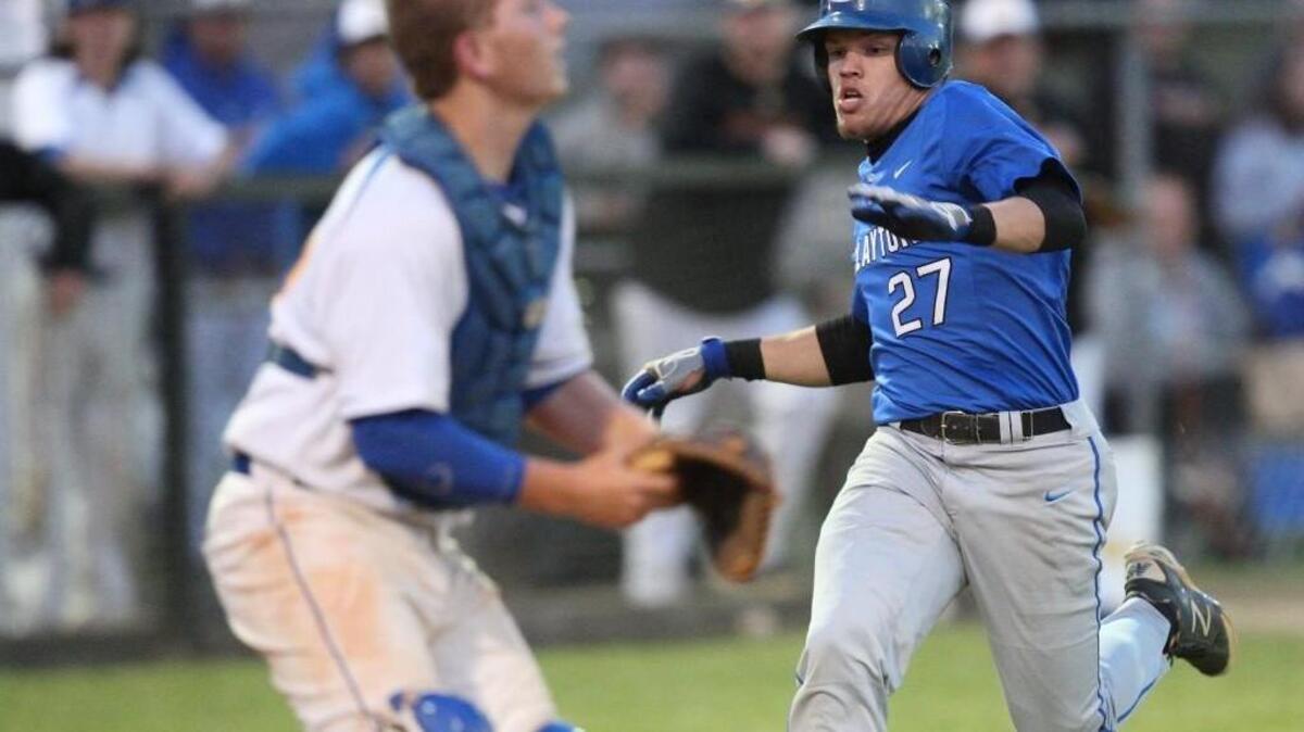 Clayton's Blake Joyner (27) runs home as Garner's Noah Kieft (10) waits for the ball during the Garner Trojans High School game against the Clayton Comets on April 15, 2016, in Garner, N..C. The Clayton Comets won the game 12-1.