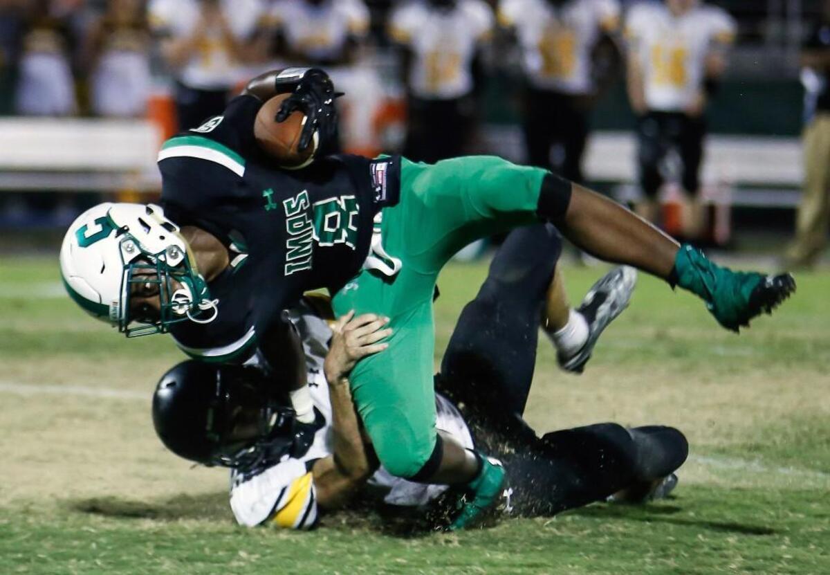 Apex defender Judson Griffin (6), left, drags down Cary's Keeyon Hicks (8) on an end-around in the backfield for a big loss during Apex's football game at Cary on Friday, September 16, 2016. Apex won the game 35-34.