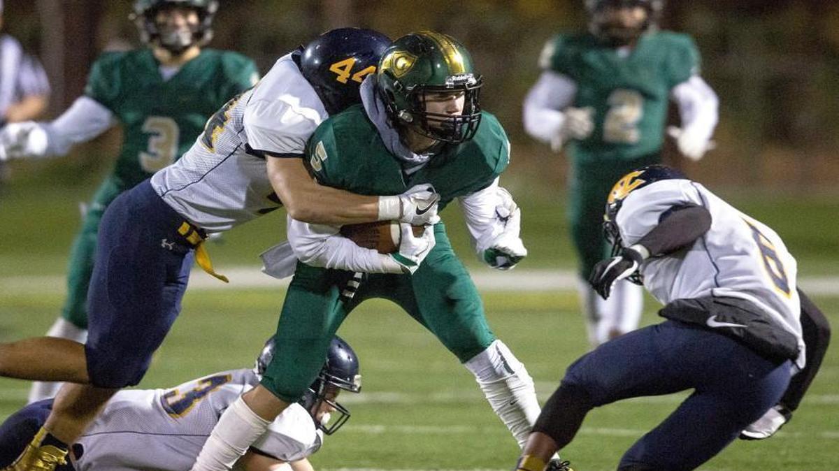 Cardinal Gibbons' Jack Biestek (5) carries the ball as D.H. Conley's Ryder Bennett (44) attempts a tackle during a high school football game in Raleigh, N.C. on Friday, Nov. 18, 2016.