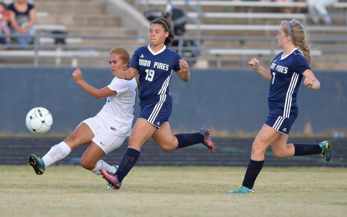 Jasmine Hernandez, left, of Southern Lee takes a shot on goal against Trinity Balloue (19) and Allyson Gailey (7) of Union Pines. The Southern Lee Cavaliers played the Union Pines Vikings in a girls soccer game that took place in Sanford, N.C. on Wednesday, May 3 2017. Southern Lee won 2-0.