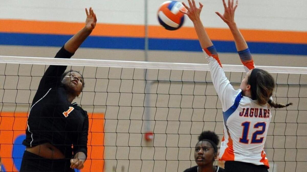 Athens Drive's Allison Lake (12) defends a spike by Fuquay-Varina's Byona Spence (1) during the volleyball game in Raleigh on Tuesday, August 23, 2016. Fuquay-Varina won 3-0.