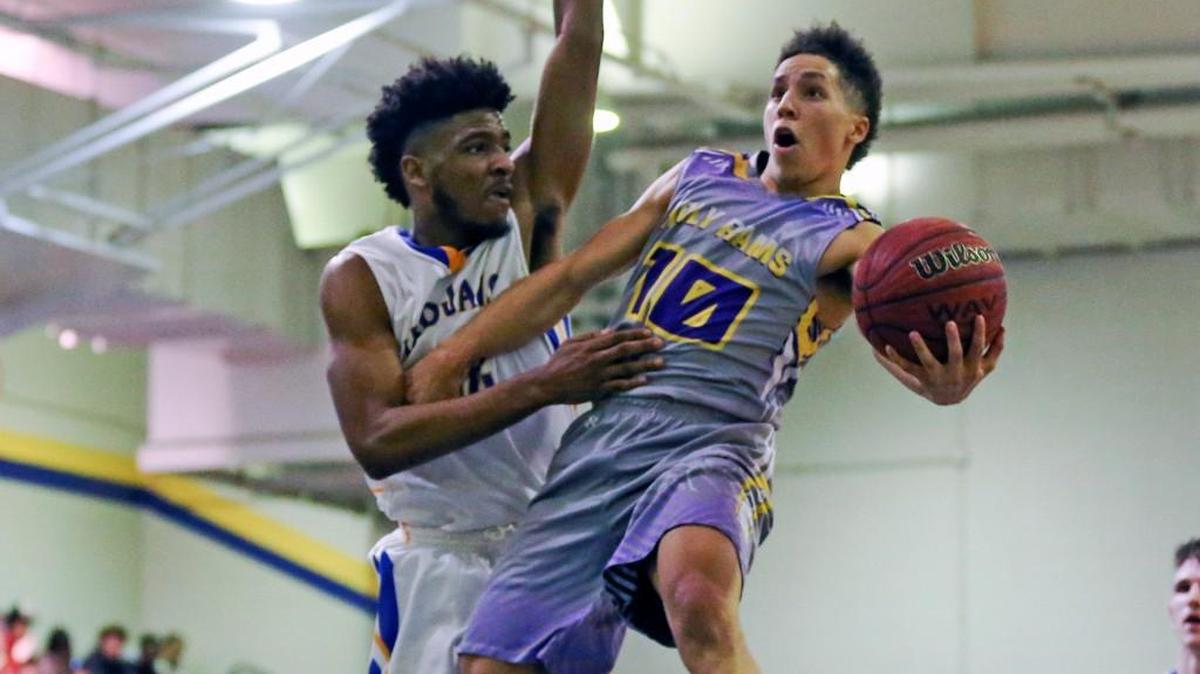 Word of God’s DK Simmons (10) drives by Garner's Kenyon Burt (22) to score just before the first half buzzer sounds. Coverage from the high school basketball game between the Word of God Holy Rams and the Trojans of Garner High played in Garner, N.C. on Wednesday, January 13, 2016. Garner defeated Word of God 93-89.