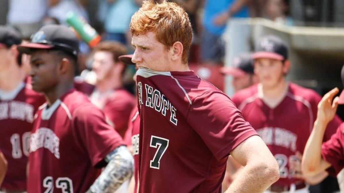 Green Hope catcher Drew Hegeman (7) reacts as he watches the North Davidson team celebrate their 4A state championship on Saturday afternoon at Five County Stadium in Zebulon.