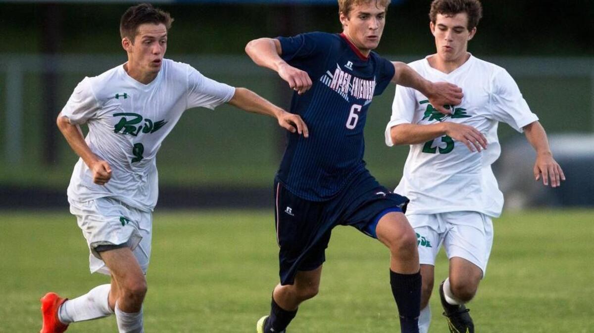 Apex Friendship's Will Flynt (6) dribbles past Leesville's Grant Nelson (9) and Robert Bailey (23) during a high school boy's soccer game in Raleigh, N.C. on Monday, Aug. 15, 2016.