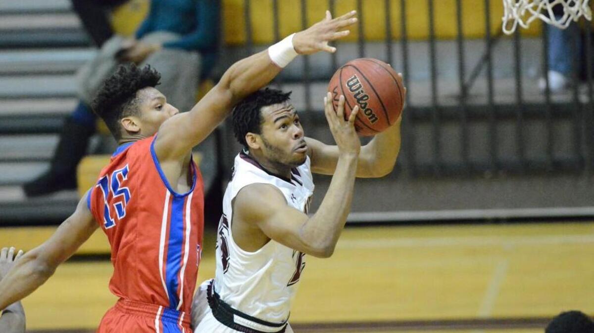 Jaylane Eddie, right, of Wakefield scores a basket against John Jiles, left, of Wake Forest. The Wake Forest Cougars played the Wakefield Wolverines in a men basketball game that took place in Raleigh, N.C. on Friday, January 27, 2017. Wakefield won 69-62.