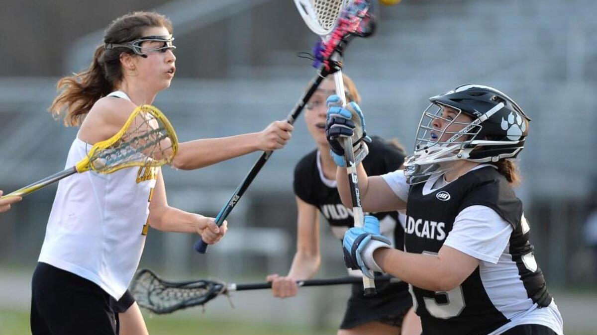 Anne Crabill, left, of Chapel Hill shoots past Jordan Metzbower, right, East Chapel Hill's goalkeeper to score a goal for the Tigers during Chapel Hill’s 17-14 victory.