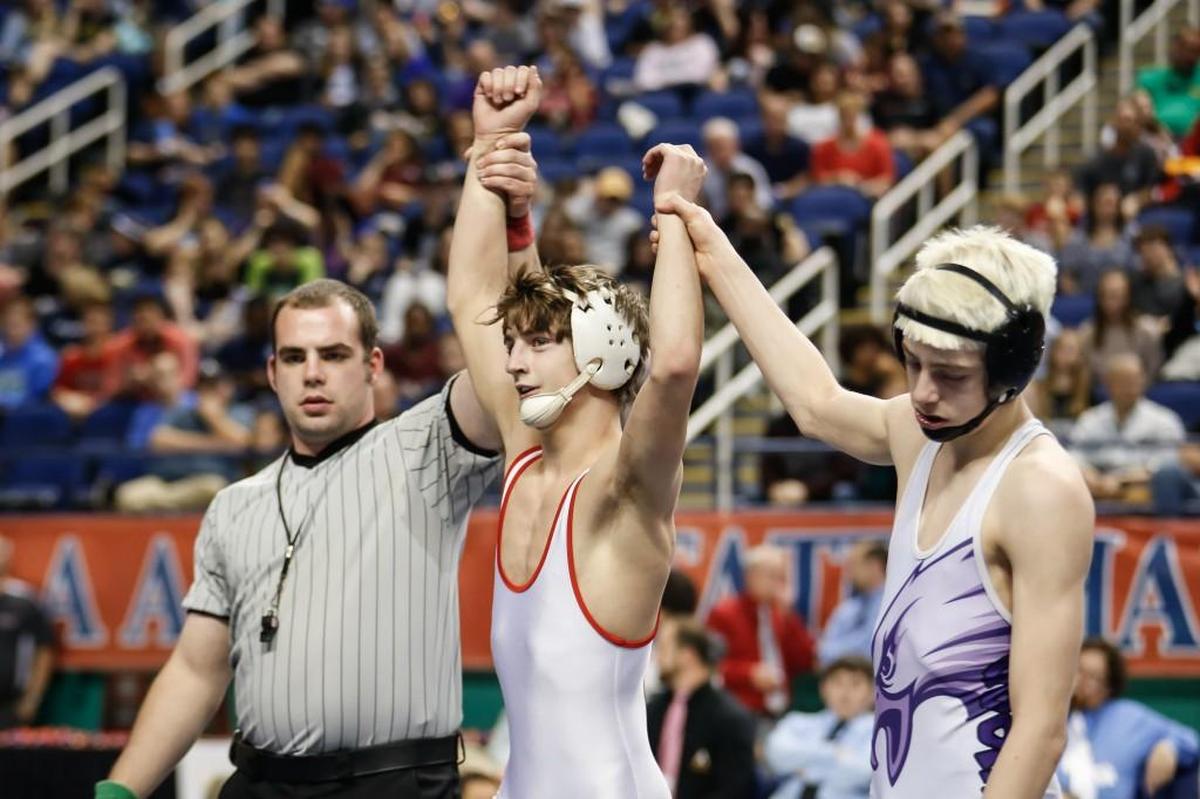 Chatham Central's Nick Daggett, center, celebrates his third state championship with the help of his opponent, Rosewood's Chris Hill, during the NCHSAA Wrestling State Championship in Greensboro on Saturday, February 18, 2017.