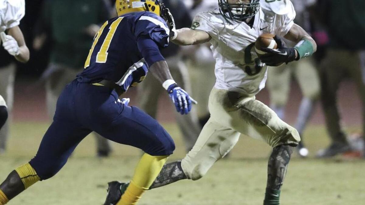 South Johnston's Kavante Johnson (9) stiff arms Rocky Mount's Detrell Revis (31) to pick up additional yardage for the Trojans. Coverage of the 2nd round of the 3A NCHSAA football playoffs between the South Johnston Trojans and the Rocky Mount Gryphons played in Rocky Mount, N.C. on Friday, November 18, 2015. Rocky Mount leads 10-7 at the half.