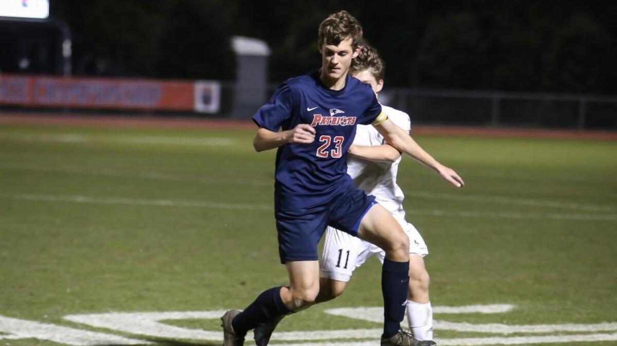 Franklin Academy's Christian Fitzgerald chases down a pass as Bishop McGuinness's Nick Desalvo (11) pressures. The Franklin Academy Patriots played against the Bishop McGuinness Villains in the 1A NCHSAA State Championship in Raleigh on Saturday, November 18, 2017. Bishop McGuinness won the game 2-0.