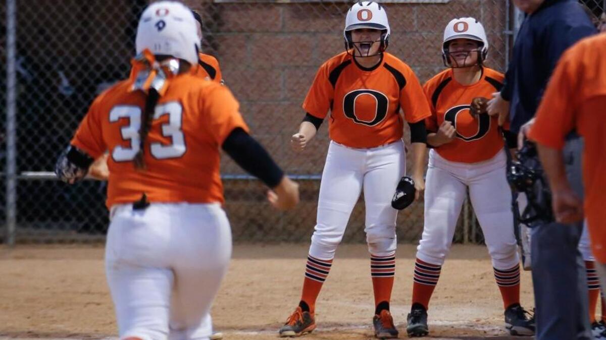 Orange's Mia Davidson (33) heads home after a homerun with her teammates surrounding the plate during Northwood's softball game at Orange on Friday, April 15, 2016. Orange won the game 5-4 in 9 innings.