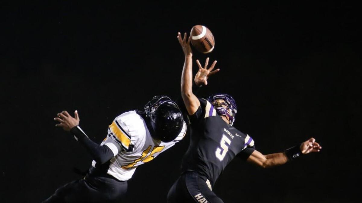 Holly Springs defender Yavel Morris (5) breaks up a pass to Apex receiver Ian Boyd (15) during Apex's football game at Holly Springs on Friday, September 25, 2015. Holly Springs won the game 28-14.