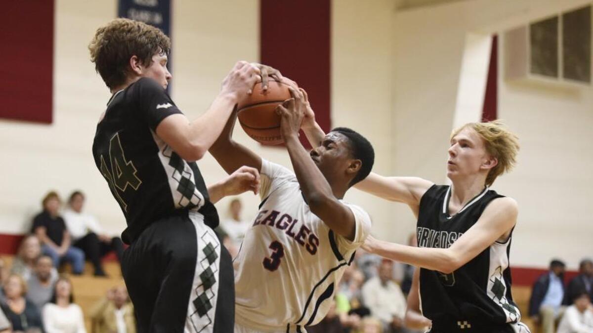 Friendship Christian's Caleb Soemer (14) and Chase Gunter (5) fight for the ball with Raleigh Christian's Lavelle Gilchrist (3) in Raleigh, N.C. on Thursday, January 12, 2017. Raleigh Christian won 52-40.