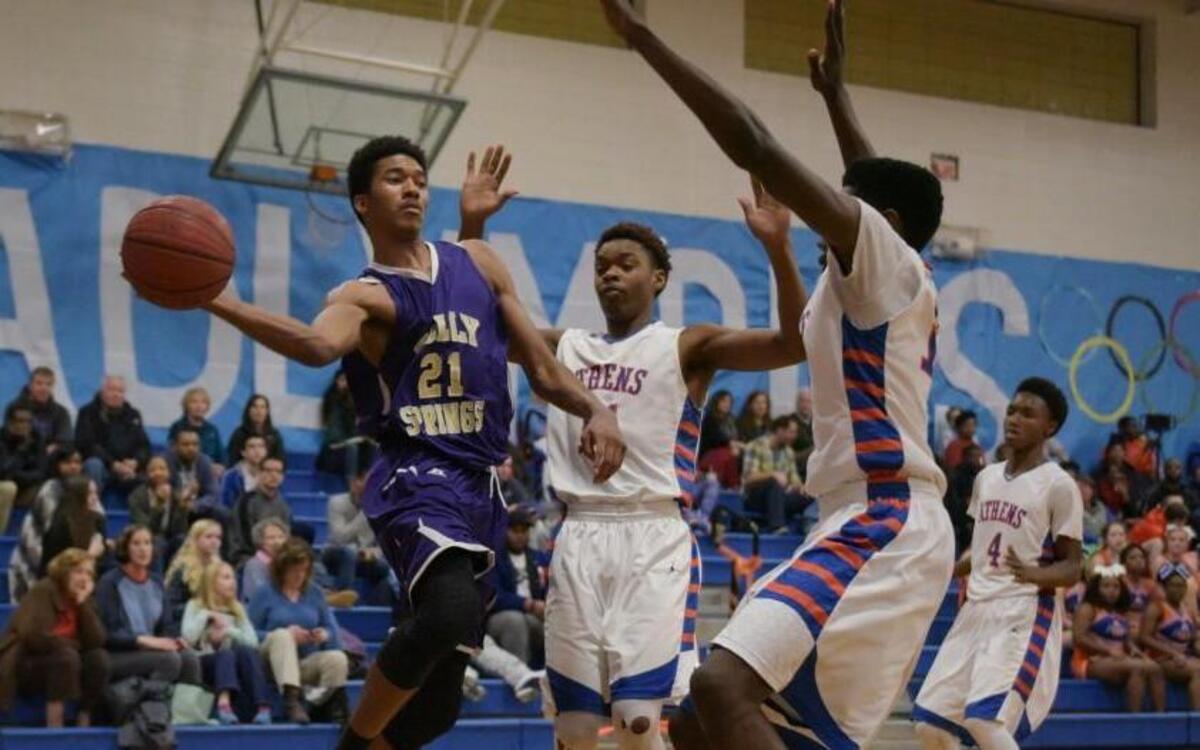 Holly Springs Hawk Jordan Brown (21) passes the ball under the basket as the Holly Spring Hawks took on the Athens Drive Jaguars at Athens Drive High School in Raleigh, NC on Friday, February 5.