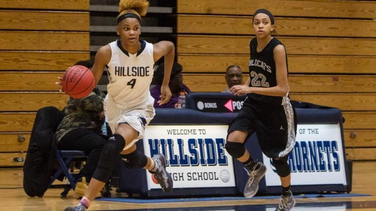 Hillside’s Elisia Grissett races down the court ahead of East Chapel Hill’s T.J. Johnson.