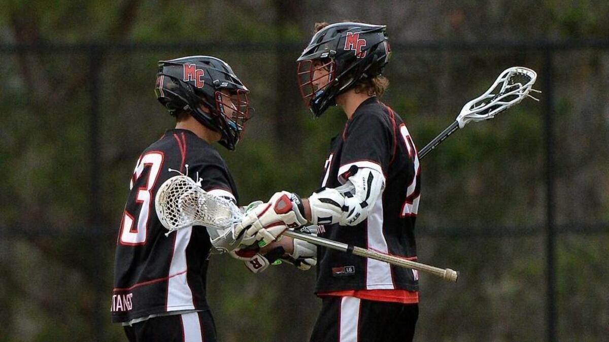 Middle Creek's Owen Caputo (22), left, congratulates teammate David Baird (13) after his scored goal.The Holly Springs Golden Hawks and the Middle Creek Mustangs met in a regular season lacrosse game in Holly Springs, N.C. on March 29, 2018.