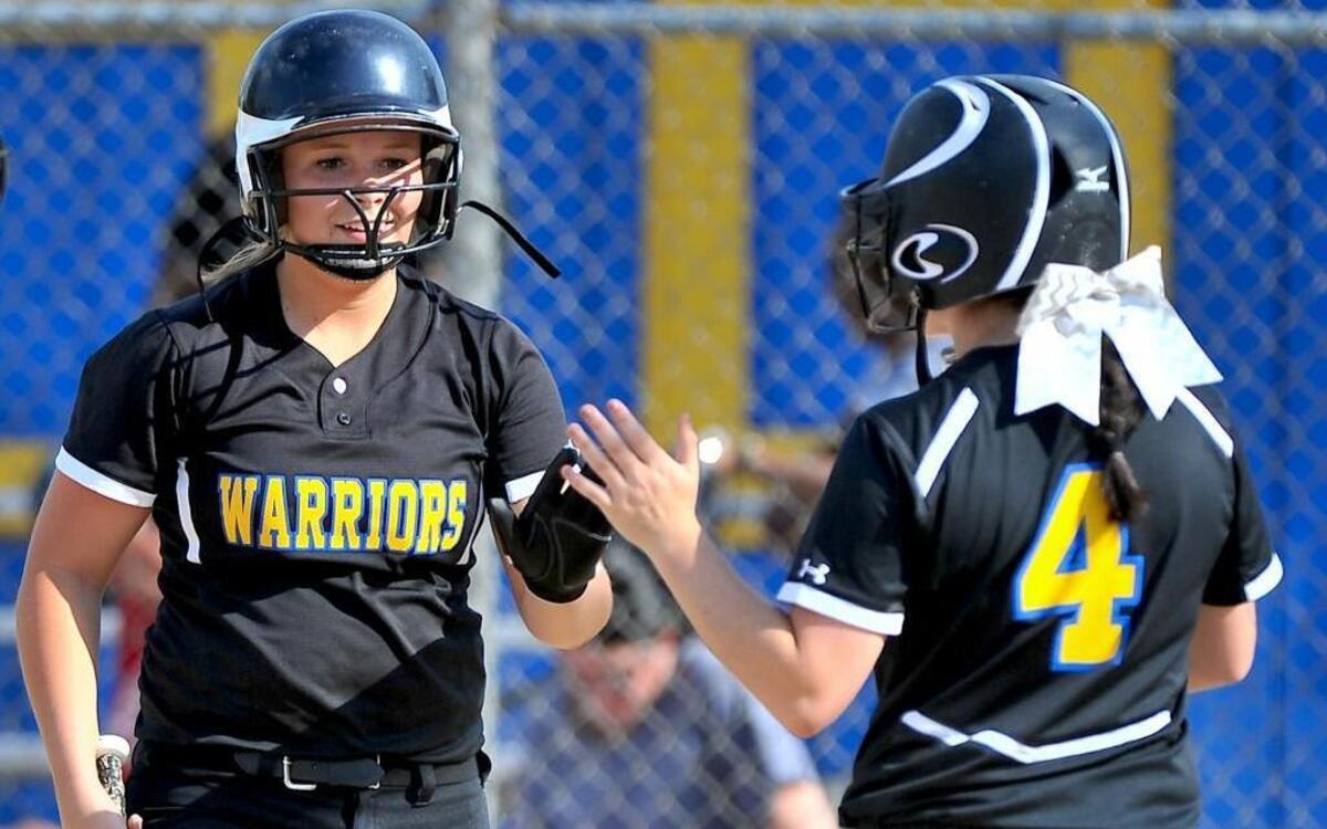 East Wake’s Gracen Sessoms (4) is congratulated by teammate Bailey Watkins (11) after Sessoms’ score . The East Wake Warriors took on the Knightdale Knights in softball on April 27, 2016 in Wendell, N.C. East Wake won 11-0.
