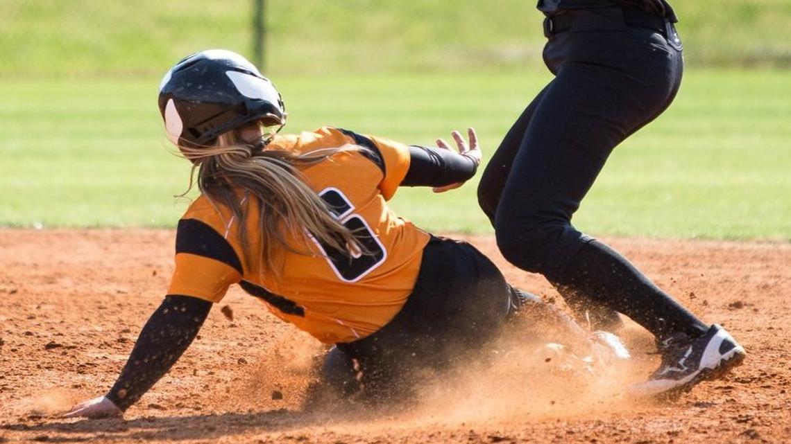 Panther Creek's Corinne Somers (9) winds up to throw to first base as Fuquay-Varina's Chloe Baker (6) slides into second base during a high school softball game in Fuquay-Varina, N.C. on Wednesday, May 4, 2016.