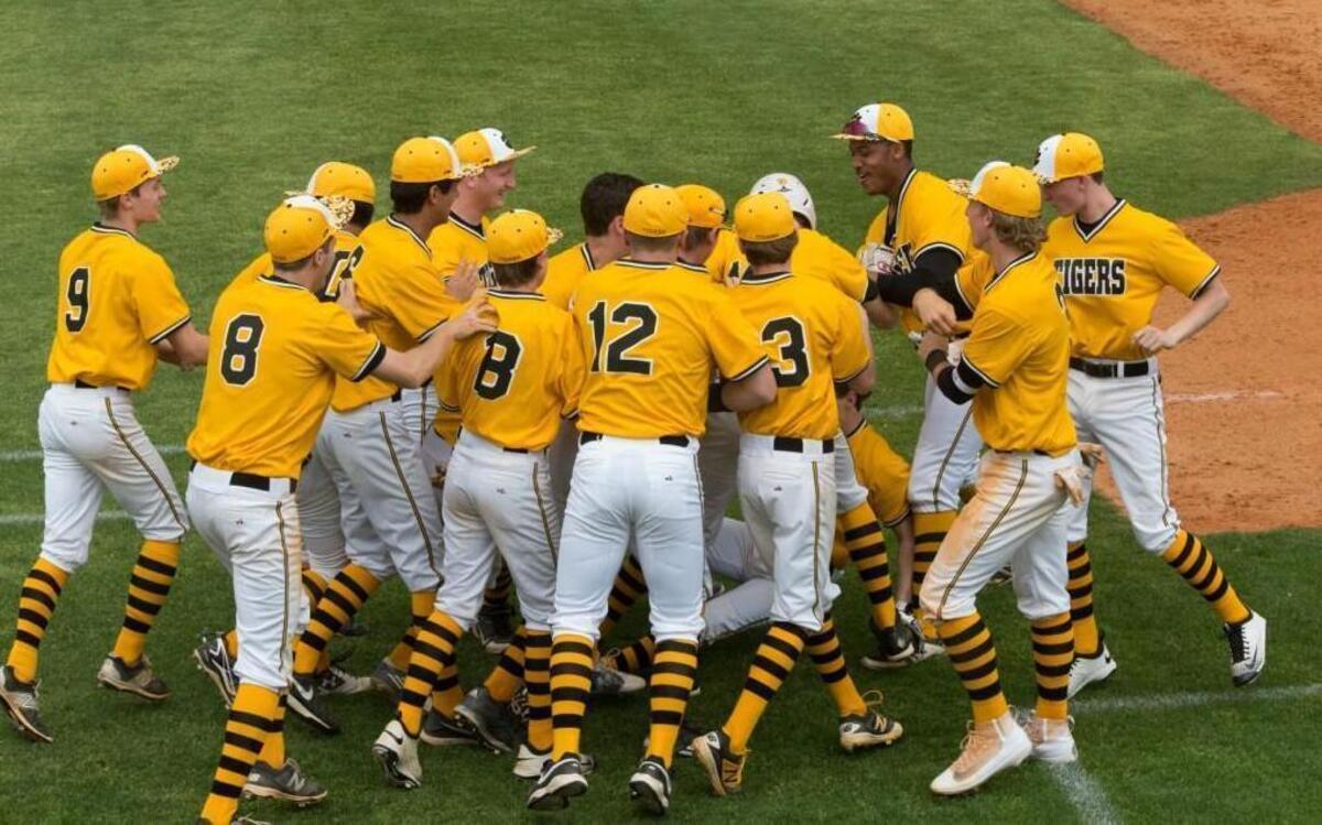 Chapel Hill players mob Garrett Liebe (obscured) after he scores the game-winning run in the bottom of the ninth inning Thursday against Athens Drive, as the Tigers win 5-4 on opening day of the Hilltop Invitational Tournament.