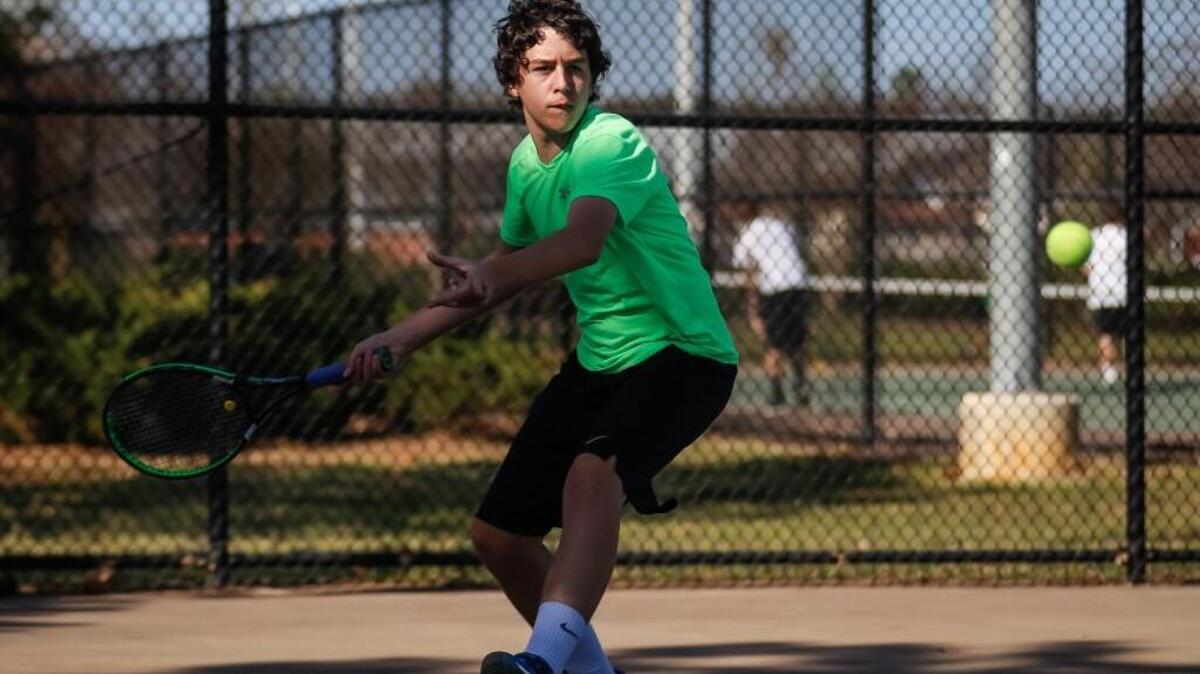 Cary's' Liam Martin in his doubles match with teammate Cameron Friedland, winning the match 8-6, during Cary's boys' tennis match at Holly Springs on Thursday, March 17, 2016.