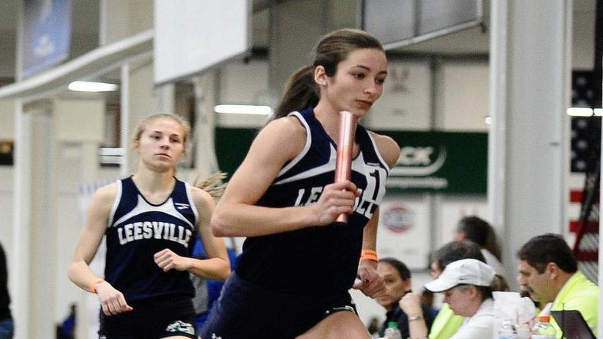 Leesville Road's Sydney Winchell passes the baton to Nevada Mareno for the final leg of their Championship run of the girl's 4x800 meter relay, during The NCHSAA 4A Indoor Track and Field Championship. Saturday February 14, 2015, Winston Salem, N.C.