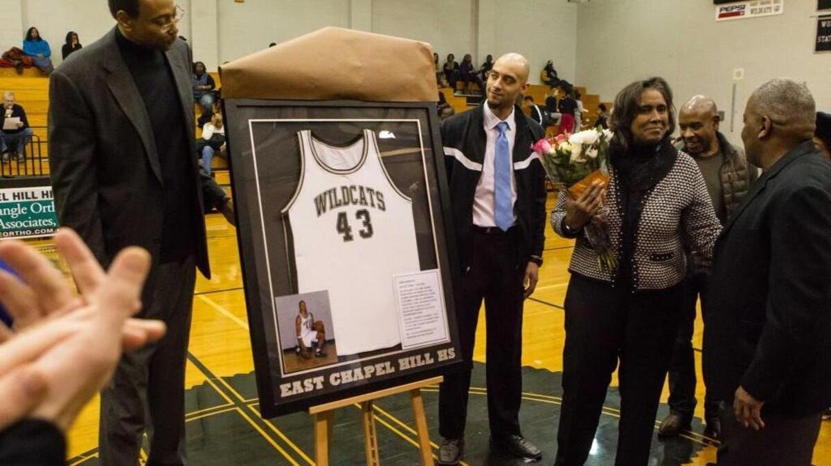The late Chris Hobbs (East Chapel Hill class of 2000) has his jersey retired during a ceremony between the boys and girls game. Mary Berry-Hobbs (Chris's mom) speaks with Wildcat head coach Ray Hartsfield who coached Chris.