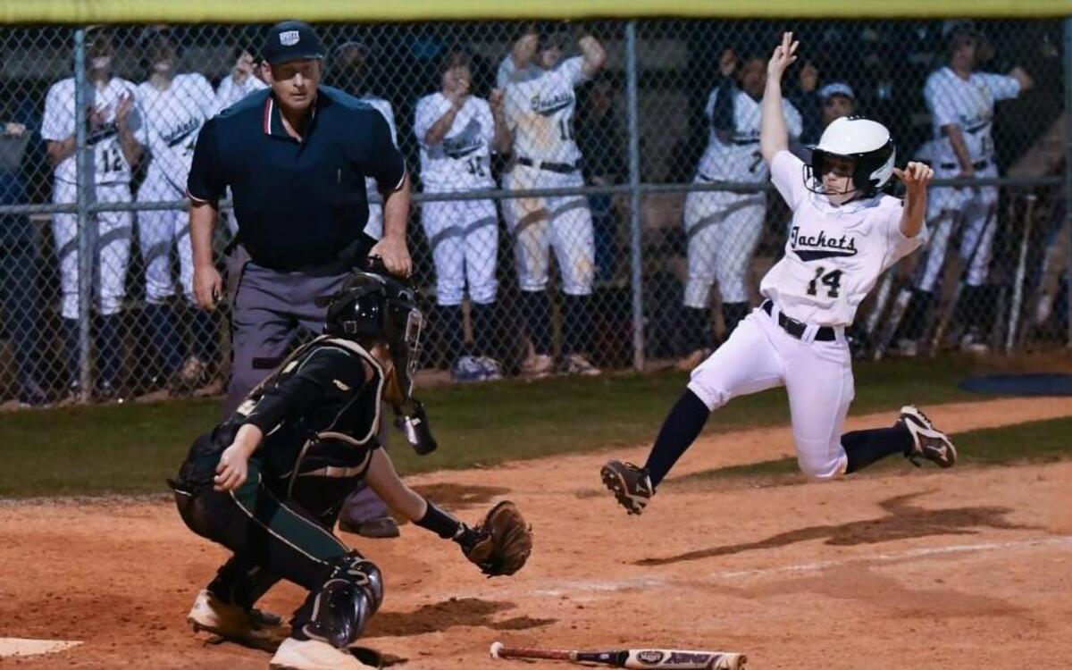 Kelsey Kirkman (14) of Lee County slides in to home but gets put out by Pinecrest catcher Alyssa Drake (15) .The Lee County Yellow Jackets played the Pinecrest Patriots in a softball game that took place in Sanford, N.C. on Thursday, March 9 2017. Lee County won 4-3.