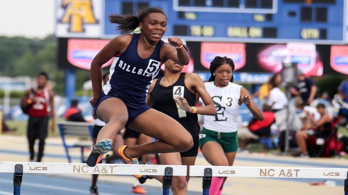 Hillside's Jessica Wright (5) clears the final hurdle on her way to winning the 300 meter hurdles, with Southeast Raleigh's Sierra Fletcher (3) finishing in second place, during the NCHSAA 2A and 4A track and field state championships in Greensboro on Friday, May 19, 2017. Hillside's girls won the team title, and Southeast Raleigh finished as runner-up.