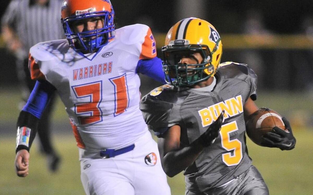 Bunn's Bruce Adams Jr. (5) runs for yardage ahead of Louisburg's Devon Ingraham (3). Louisburg Warriors took on the Bunn Wildcats in football in Bunn, N.C. on September 18, 2015. Bunn wins 62-6.