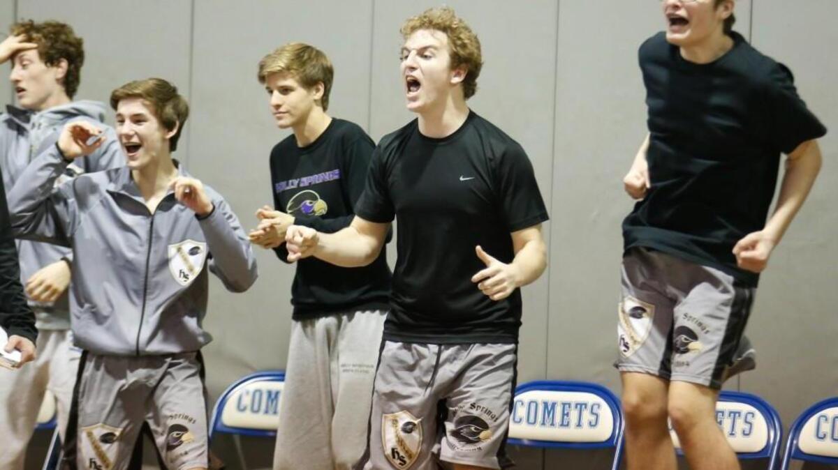 Holly Springs wrestlers celebrate the last-second victory of Ed Callihan in the 160-pound match to secure the team victory in Durham Riverside's playoff wrestling match against Holly Springs at Clayton on Tuesday, February 2, 2016. Holly Springs won the match 37-35.
