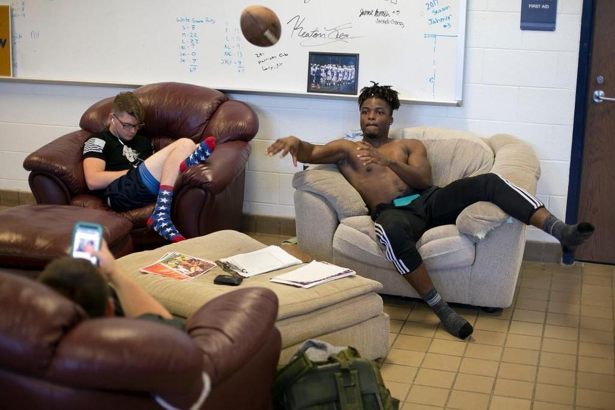 After working out in the weight room during his first period class, Jahmir Smith and his classmates toss the football around in the locker room at Lee Senior High School.