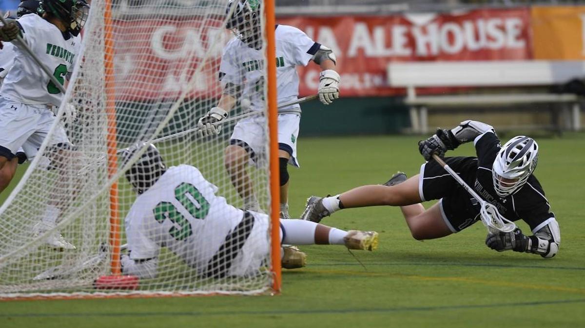 Ryan Levy, right, of East Chapel Hill takes a shot on goal against goal keeper Bryce Cheek (30) of Weddington. The East Chapel Hill Wildcats played the Weddington Warriors in a boys lacrosse game that counted for the NCHSAA 1A/2A/3A championship at the WakeMed Soccer Park in Cary, N.C. on May 18, 2018.