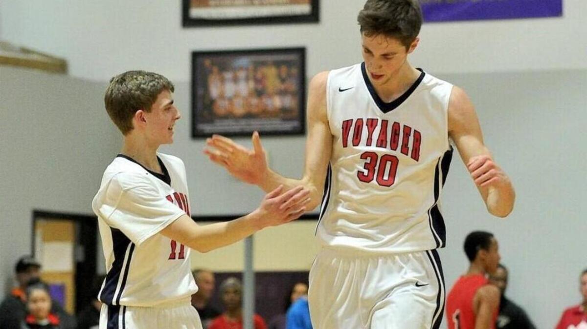 Jay Huff (30) gets a hand slap from a teammate after a basket for Voyager Academy.