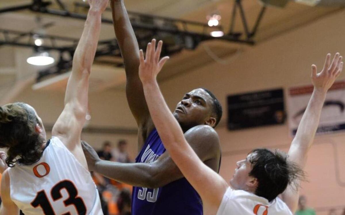 Jordon Riley, center, of Riverside drives to the basket against Daniel Mulligam (13) and Logan Vosburg (22) of Orange. The Orange Panthers played the Riverside Pirates in Hillsborough, N.C. on Tuesday, December 15, 2015. Riverside won 72-64.