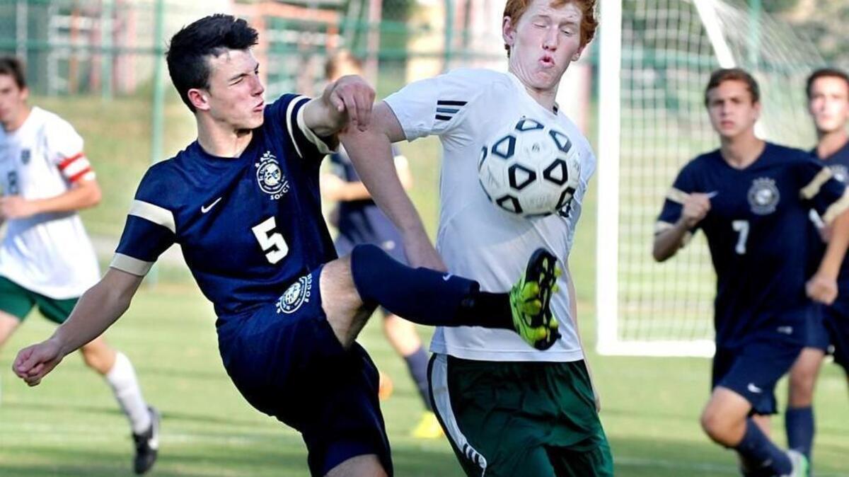 St. David's School's Jose Cornejo (5) boots the ball in front of Ravencroft's Alex Lindsay during the boys soccer game in Raleigh on September 9, 2015. Ravenscroft won the match 2-0.