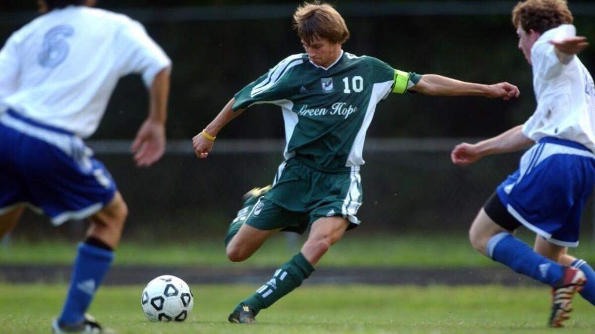 Green Hope's Stephen Bickford strikes a shot between Athens Drive defenders during Tuesday's game. Bickford scored four times in his team's 4-0 win over Athens Drive, the defending state 4A champion at the time.