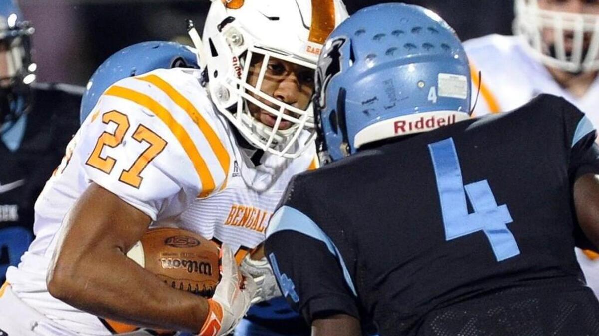 Fuquay-Varina’s Josh Arrington (27) is stopped by Panther Creek's Charles Edwards (4) during the football game, which was played on Friday, October 30, 2015 in Cary.