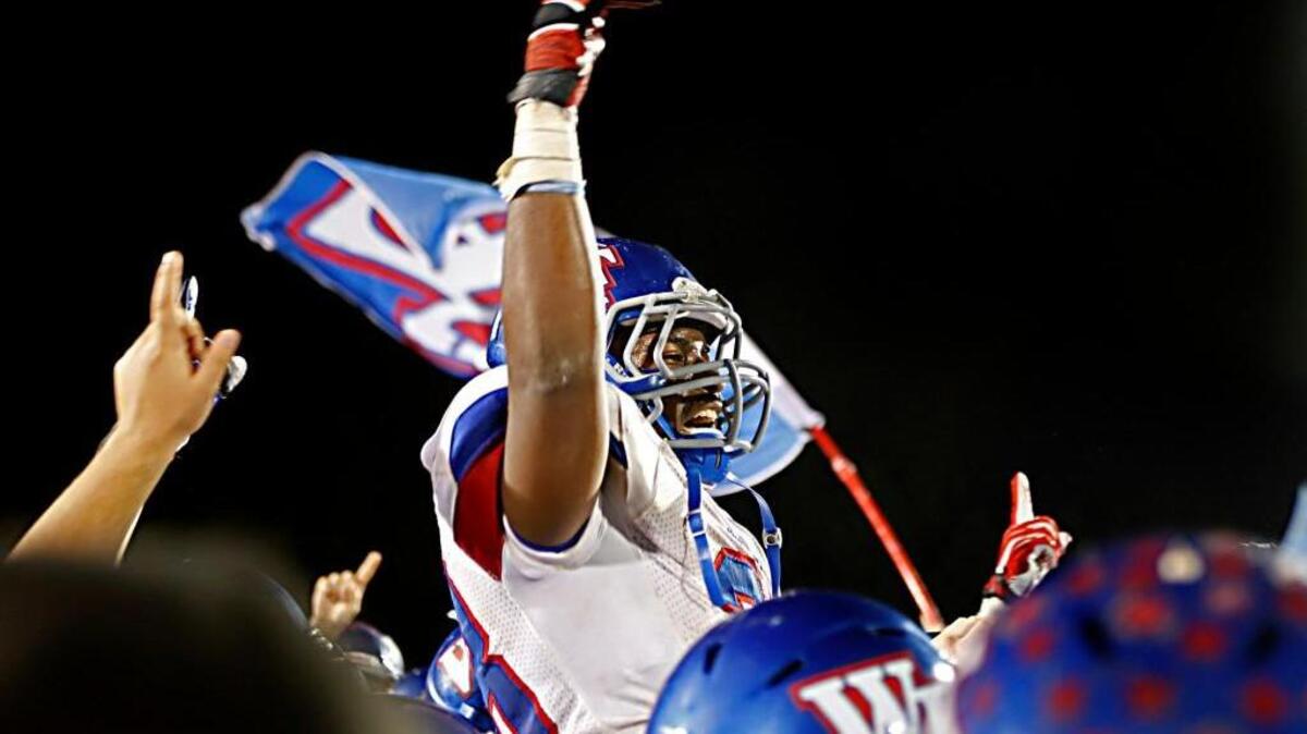 Wake Forest back Jamal Sweet is lifted above the crowd by his teammates as the team celebrates following Wake Forest-Roleville’s fourth-round playoff game at Middle Creek on Friday, December 6, 2013. Wake Forest-Rolesville won the game 24-23.