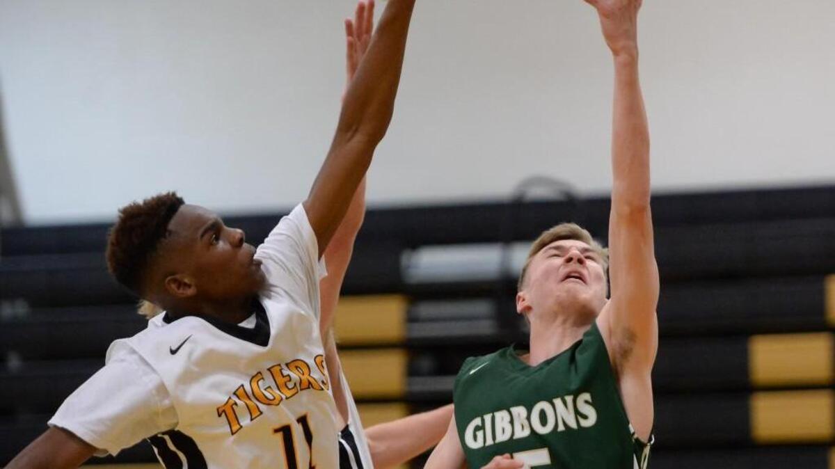 Mike Brannan (5) of Cardinal Gibbons drives with a layup against Markale Cordova (11) of Chapel Hill. The Chapel Hill Tigers played the Cardinal Gibbons Crusaders in a boys basketball game that took place in Chapel Hill, N.C. on Wednesday, January 13, 2016. Cardinal Gibbons won 66-45.