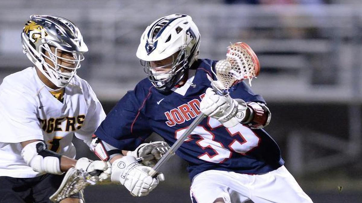 Jordan's Jared Halverson, right, charges by the Chapel Hill defender in a nonconference boys lacrosse game on March 7, 2017.